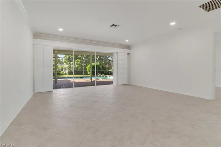 Empty room featuring a sunroom, crown molding, light tile patterned flooring, and recessed lighting