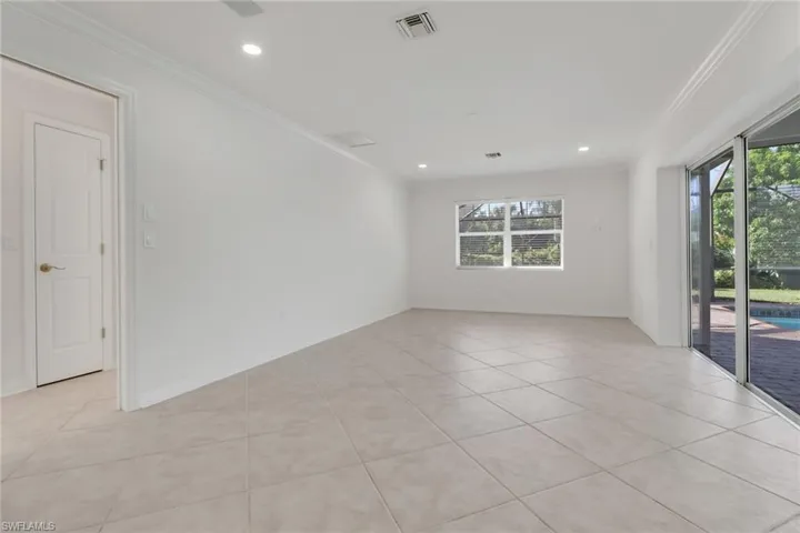 Empty room featuring ornamental molding, light tile patterned floors, and recessed lighting