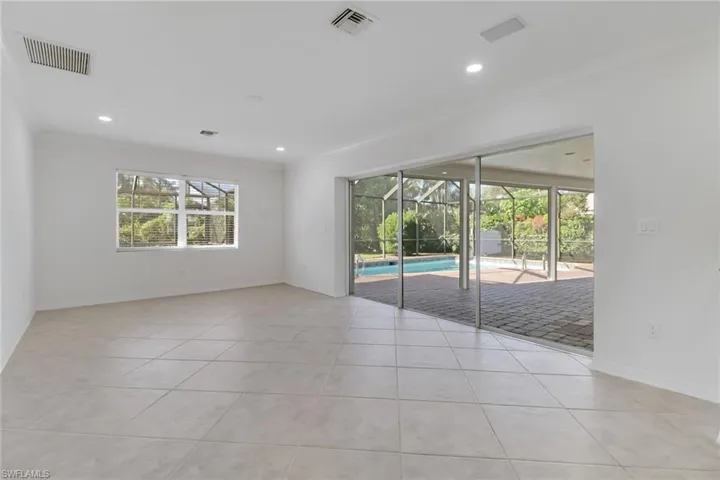 Empty room with ornamental molding, a sunroom, light tile patterned floors, and recessed lighting
