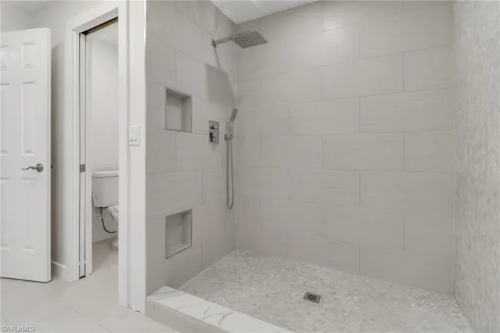 Bathroom with a shower stall and toilet