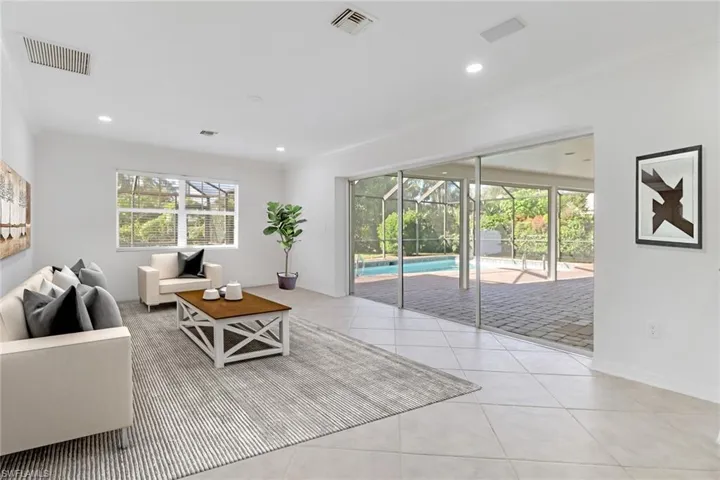 Living area with ornamental molding, a sunroom, light tile patterned floors, and recessed lighting