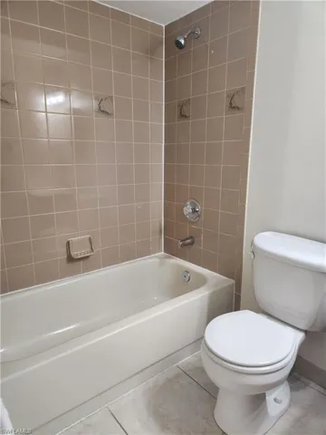 Bathroom with washtub / shower combination and tile patterned floors