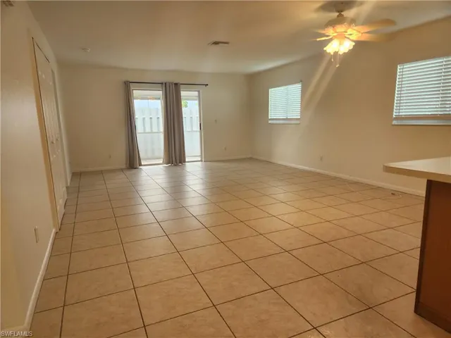 Unfurnished room featuring light tile patterned floors and ceiling fan