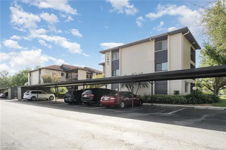 View of building exterior featuring covered parking