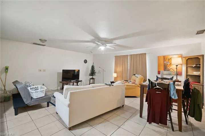 Living room with light tile patterned floors and ceiling fan