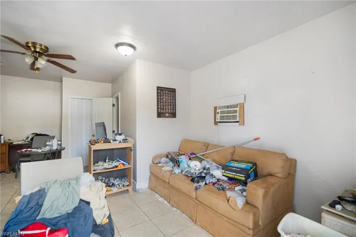 Living room featuring light tile patterned floors and ceiling fan