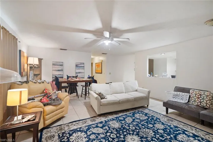 Living room featuring light tile patterned floors and ceiling fan