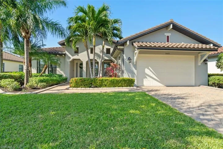 Mediterranean / spanish-style house with a garage and a front lawn