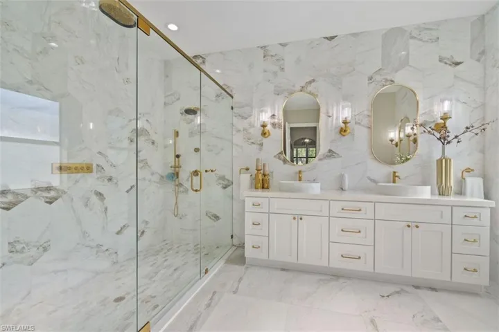 Bathroom featuring vanity, tile walls, and a shower with shower door