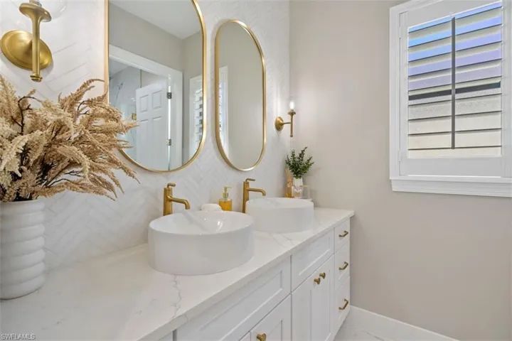 Bathroom featuring vanity and backsplash