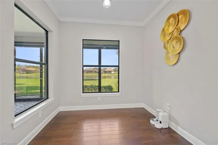 Empty room with dark wood-type flooring and ornamental molding
