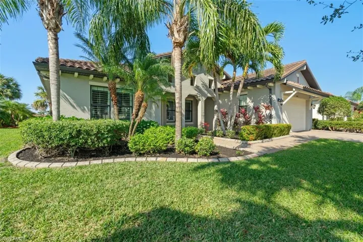 View of front of property featuring a garage and a front lawn