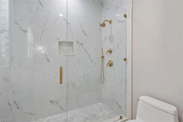 Bathroom featuring toilet and a shower with door
