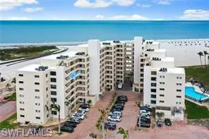 Drone / aerial view of a nearby body of water and apartment complex / building