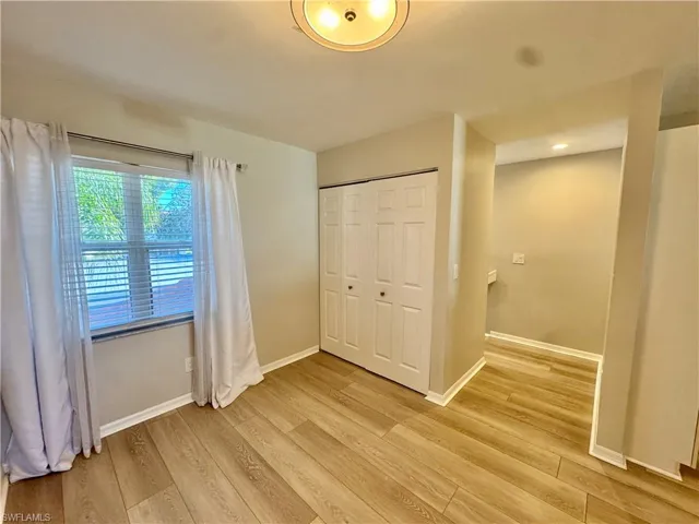 Unfurnished bedroom featuring light wood-style flooring and a closet