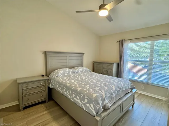 Bedroom with lofted ceiling, light wood-style floors, and a ceiling fan