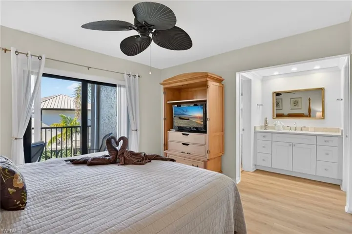 Bedroom with light wood-style flooring, access to balcony, and ceiling fan