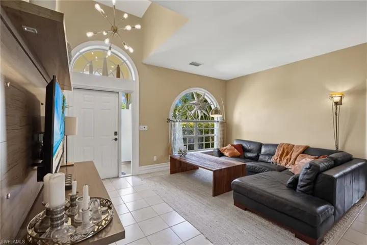 Tiled living room featuring a notable chandelier