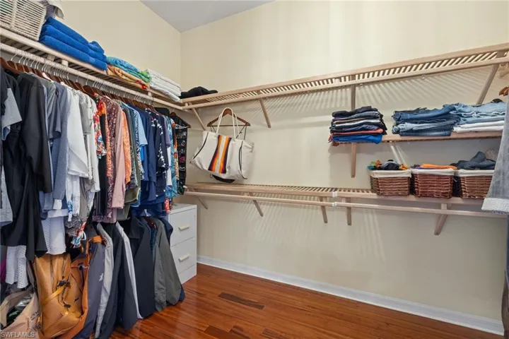 Spacious closet with hardwood / wood-style flooring