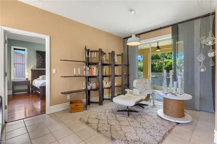 Living area featuring light tile patterned flooring and ceiling fan