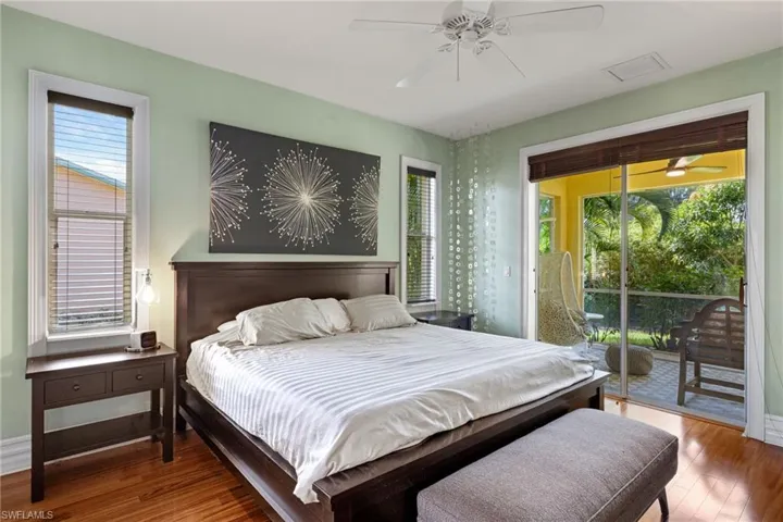 Bedroom with access to exterior, ceiling fan, and dark hardwood / wood-style flooring