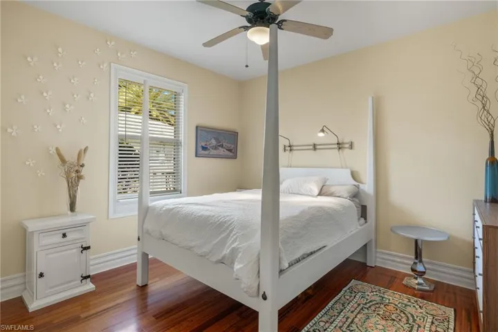 Bedroom with dark wood-type flooring and ceiling fan