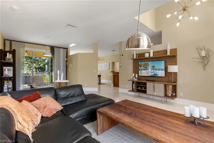 Living room with tile patterned flooring and a chandelier