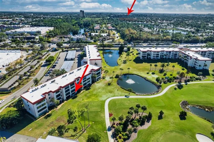 Drone / aerial view of a nearby body of water and a golf course