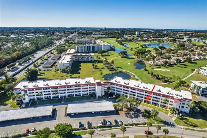 Drone / aerial view of a golf course and a nearby body of water