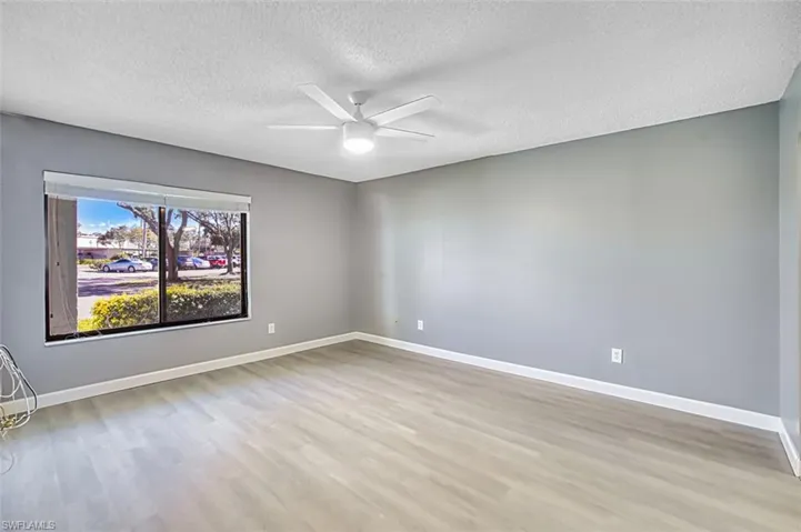 Empty room with light wood-style flooring, a textured ceiling, and a ceiling fan