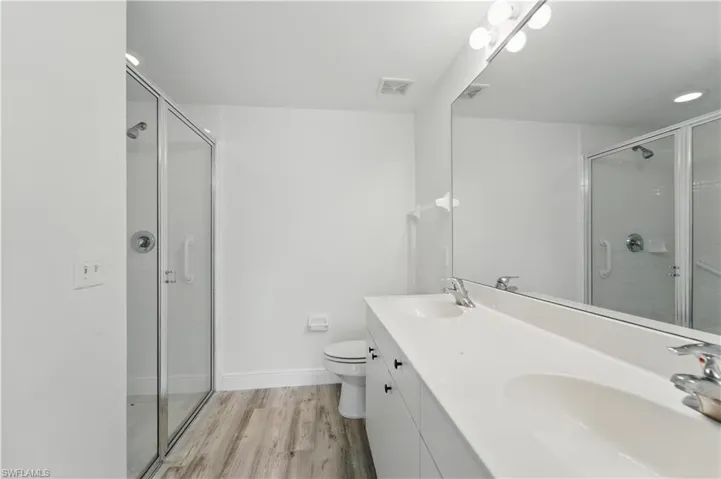 Full bathroom with a stall shower and wood finished floors