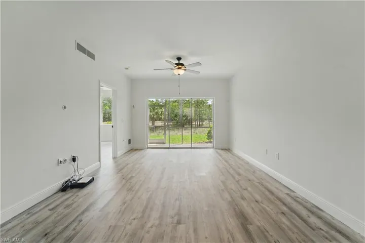 Empty room with light wood-style flooring and ceiling fan