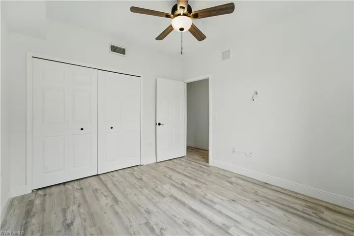 Unfurnished bedroom featuring wood finished floors, a closet, and ceiling fan