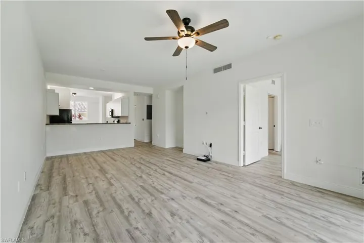 Unfurnished living room featuring ceiling fan and light wood-style floors