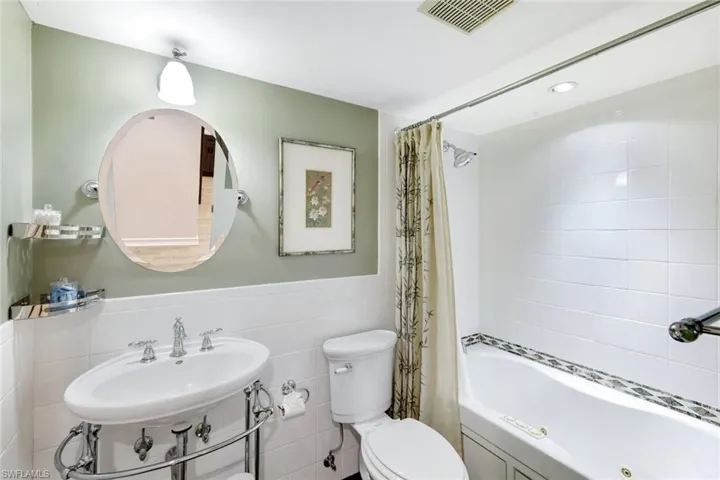 Awesome Guest Bath! Large Jetted Tub/Shower- This Bathroom has 2 Entry Doors, One From Guest Bedroom showing King Bed- All Tile