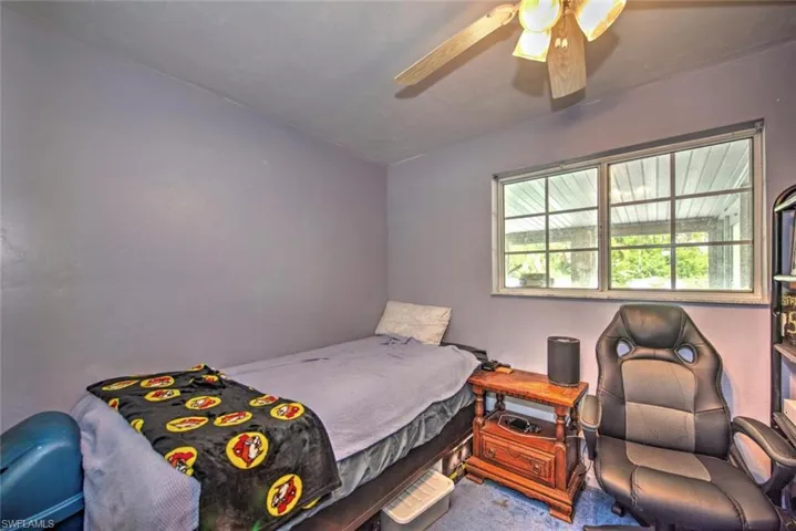 Carpeted bedroom featuring ceiling fan