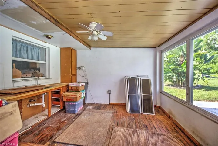 Unfurnished sunroom featuring a wealth of natural light and ceiling fan