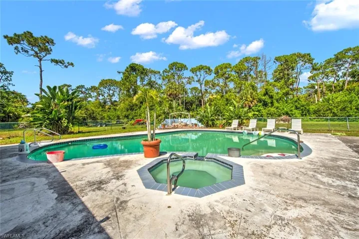 View of pool with an in ground hot tub