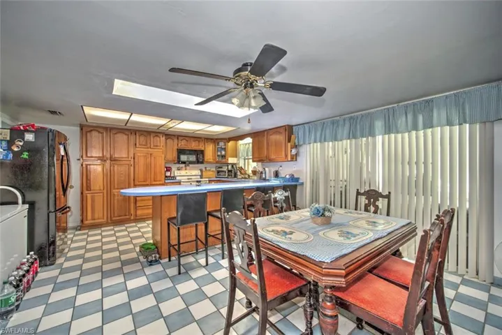 Dining room featuring a skylight, light tile patterned floors, and ceiling fan