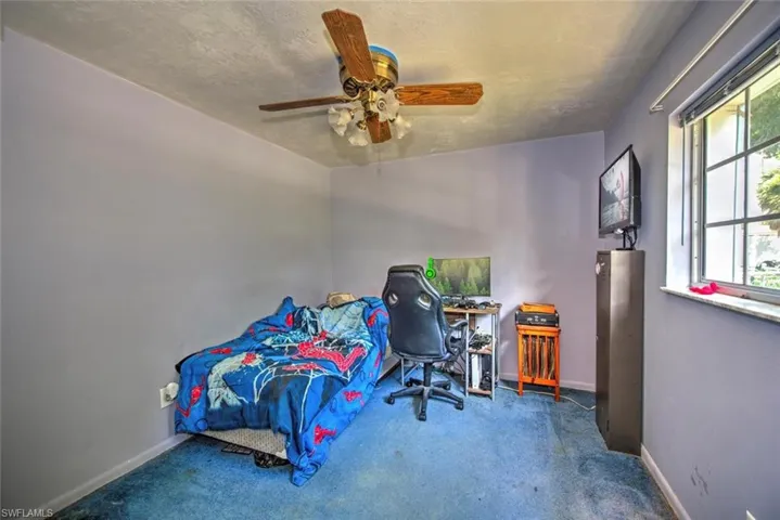 Bedroom featuring a textured ceiling, carpet, and ceiling fan