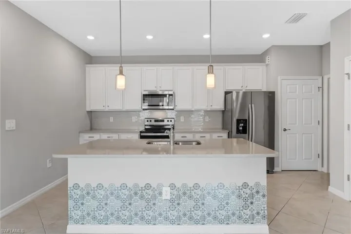 The kitchen features quartz countertops, 42-inch cabinetry, and a functional center island.