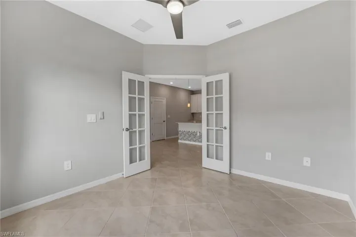 French doors open to a flexible den, ideal for a home office, guest space, or cozy media room.