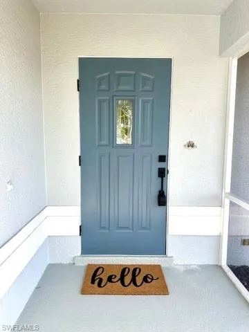 Doorway to property featuring stucco siding