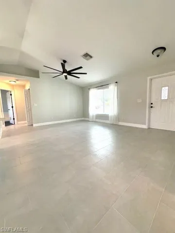 Unfurnished living room with tile patterned flooring, baseboards, ceiling fan, and visible vents