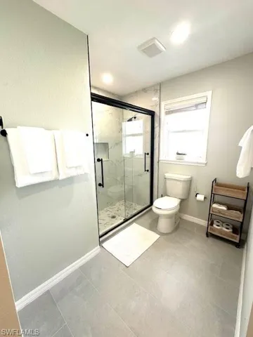 Master Full bathroom with a marble finish shower, baseboards, visible vents, and toilet