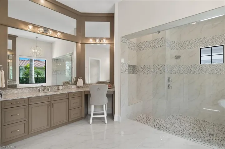 Bathroom featuring a tile shower, and vanity
