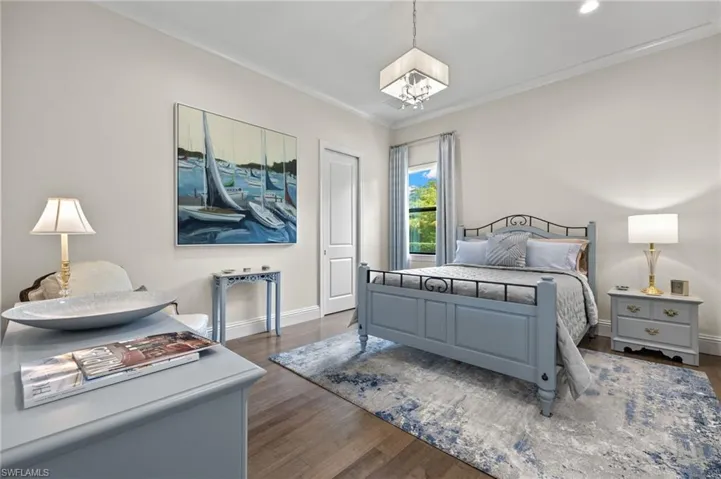 Bedroom featuring ornamental molding and light hardwood floors