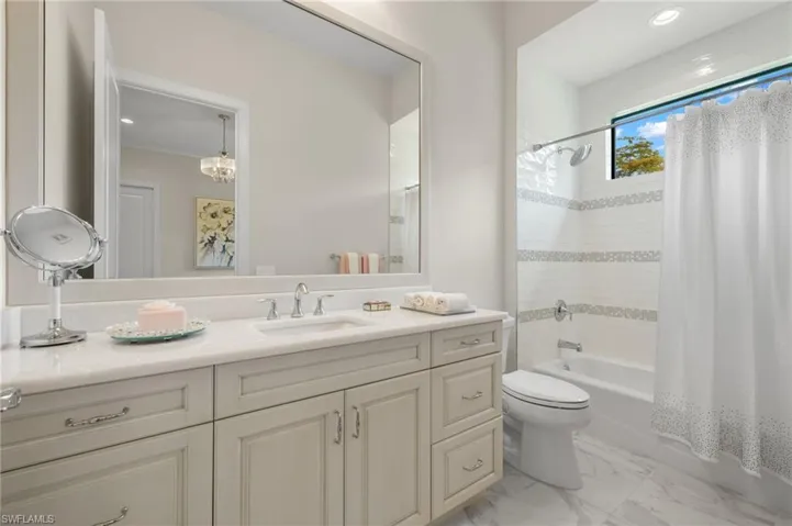 Full bathroom with vanity, crown molding, toilet, and shower / bathtub combination with curtain