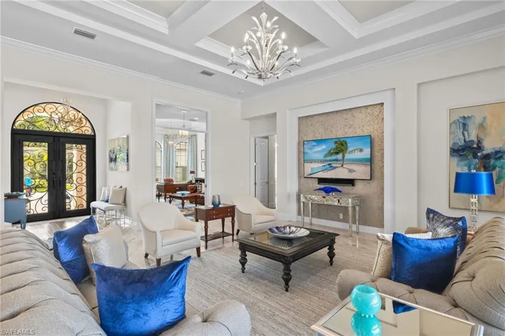 Living room with beamed ceiling, french doors, crown molding.