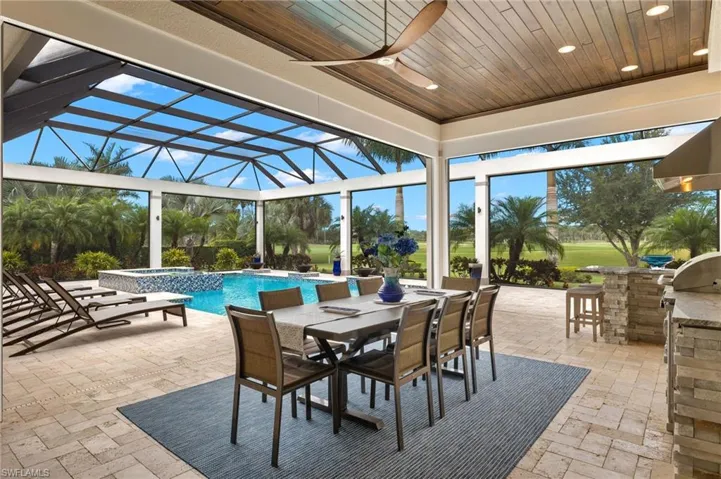 View of patio featuring exterior bar, enclosure, and ceiling fan